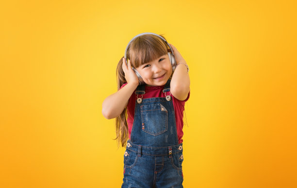 快乐的孩子喜欢戴着耳机听音乐图片下载