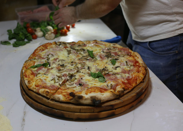 白蘑菇，火腿，朝鲜蓟，西红柿，橄榄，帕尔马干酪和马苏里拉奶酪配木背景图片图片下载