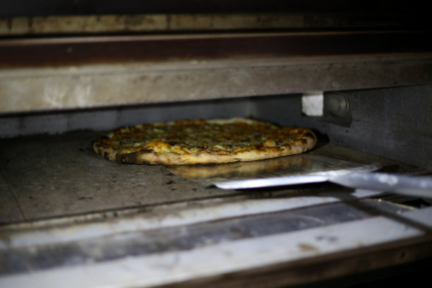 把披萨放进烤箱的照片图片下载