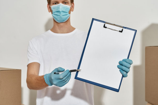 快递员拿着剪贴板和笔的照片，两边都是盒子图片下载