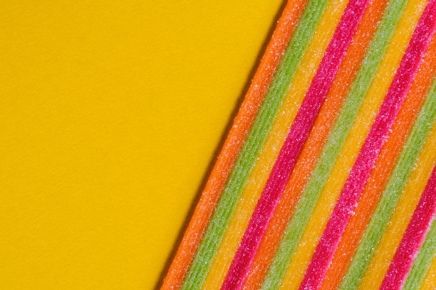 特写鲜亮美味酸甜的糖果质地，背景黄色图片下载