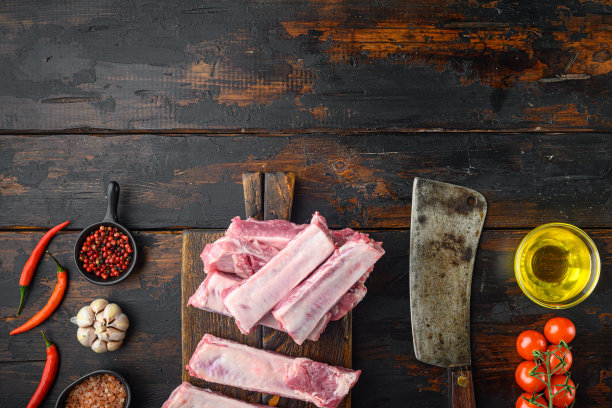 新鲜的生猪排骨配上迷迭香和大蒜，配上蜂蜜，配上旧的切肉刀，放在旧的深色木桌上，平躺着俯视图，有文字拷贝的空间图片下载
