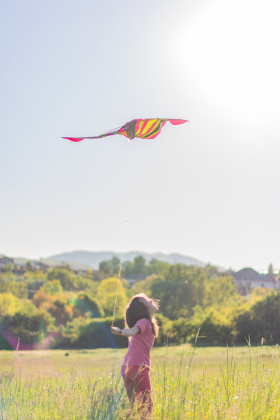 女孩在草地上放风筝图片下载