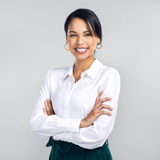 一个自信的年轻女商人在灰色背景下的摄影图片下载