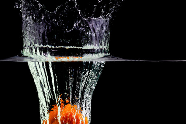 一个橙子溅起水花，冒着泡泡掉进了水里图片下载