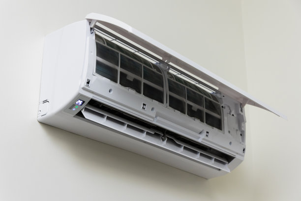 空调挂在房子的墙上。打开前盖等待维护。图片下载