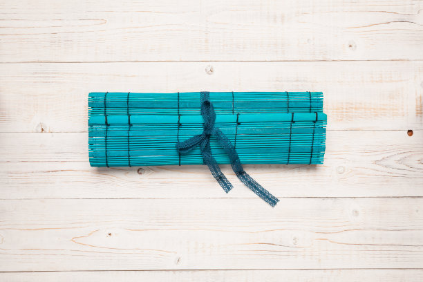 明亮的蓝绿色手工卷铅笔盒。艺术笔刷持有人在白色的木材背景。适用于工艺缝纫教程。图片下载