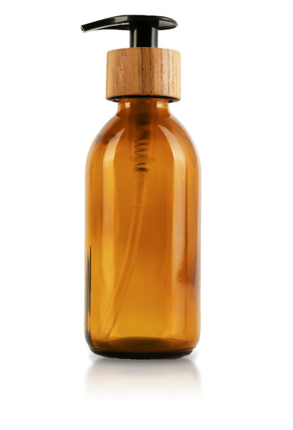 棕色玻璃瓶，带有分配器和木制塞子盖。孤立在白色背景上。环保容器的化妆品。一种容器，里面有一根吸管和一个按钮，用来装凝胶、乳液或洗发水的泵图片下载