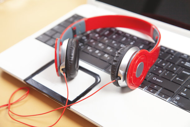 耳机在笔记本电脑键盘上。图片下载