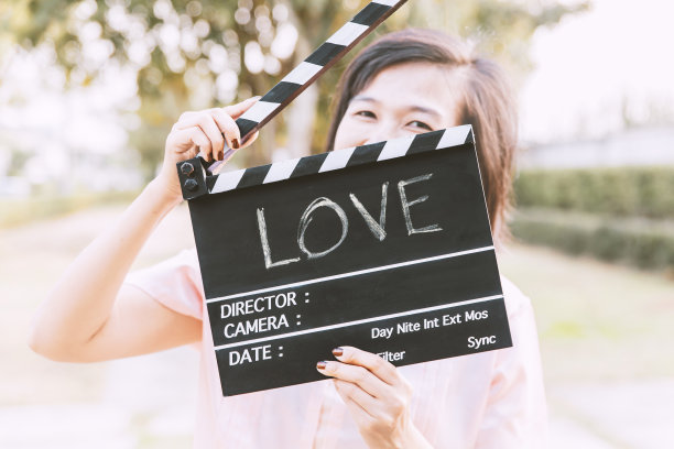 爱文本标题。手持拍板的微笑女人。图片下载