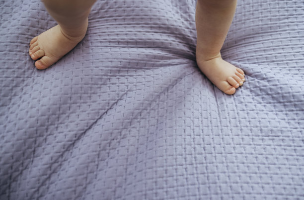 光着脚的女婴躺在薰衣草床上图片下载