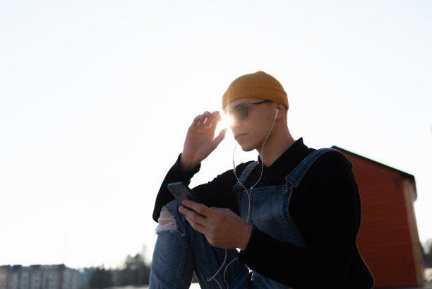 那个年轻人享受着阳光明媚的日子，听着音乐图片下载