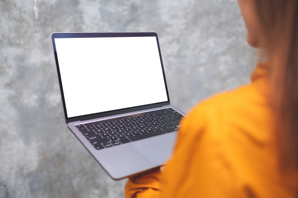 一个女人在户外拿着并使用着笔记本电脑，电脑的桌面是白色的图片下载