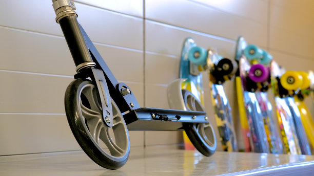 商店柜台上放着一个大轮子的滑板车。滑板在背景中是模糊的。图片下载