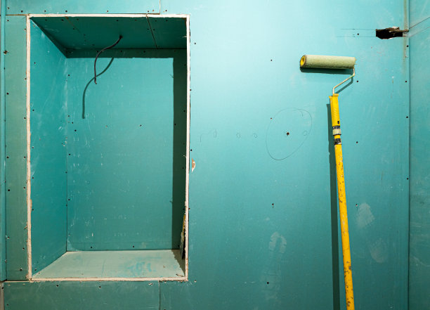 公寓正在建设、改建、翻新、扩建、修复、改建中使用的绿色石膏板或石膏板、黄色滚筒粉刷石膏板墙。图片下载