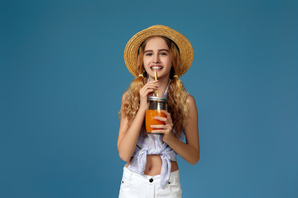 可爱的小女孩喝橙汁的肖像图片下载