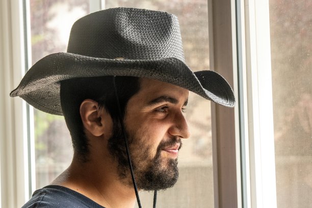 年轻的西班牙裔农业工人移民透过窗户摆姿势图片下载