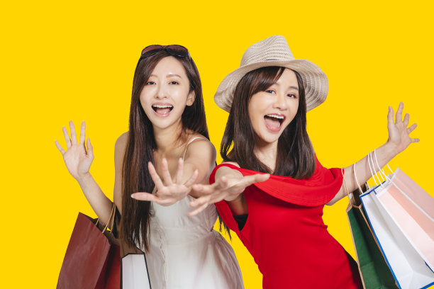 快乐的年轻女性穿着夏天的衣服拿着购物袋图片下载