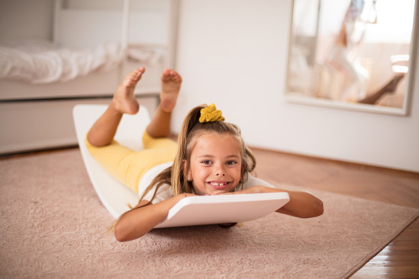 一个小女孩独自在卧室里微笑。看相机。图片下载