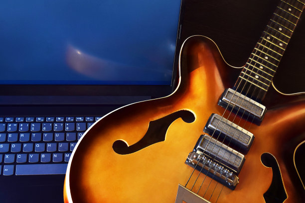 原声吉他与笔记本电脑在线吉他课程在家。图片下载