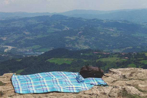 一条毛巾和一个背包，以山为背景。图片下载