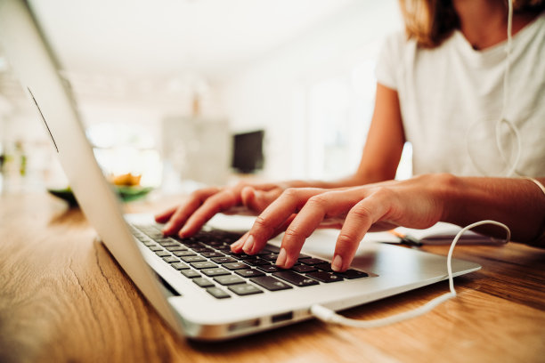 近距离观察在厨房里用笔记本电脑打字的白人女性图片下载