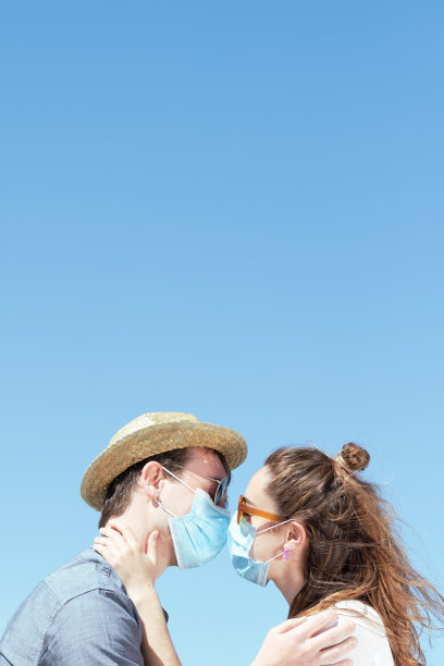 2019冠状病毒病大流行期间戴口罩接吻的情侣图片下载