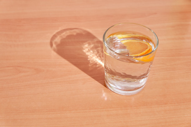 水与橙色和橙色薄片在木制的背景。健康理念，饮食健康，消化健康，新陈代谢健康。极简主义。图片下载