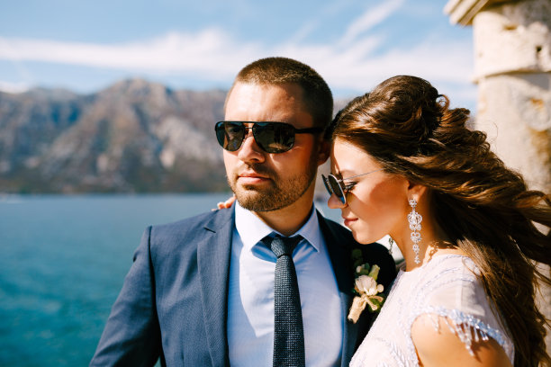 微笑的新娘拥抱新郎。她的头发在风中飘动图片下载