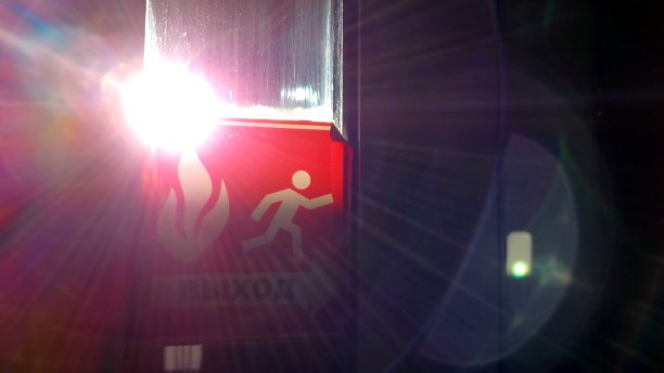 紧急出口标志，窗户上有耀眼的太阳耀斑图片下载