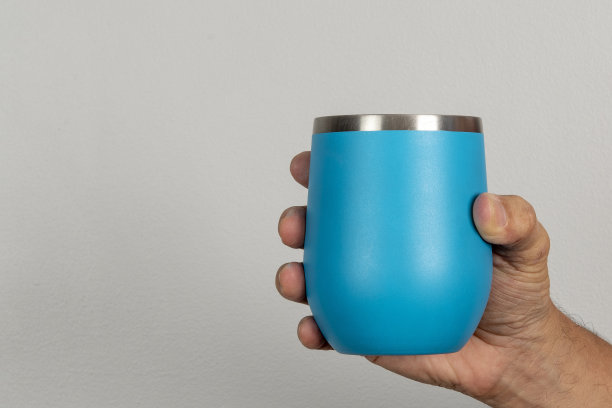 男性的手拿着一个蓝色的杯子图片下载