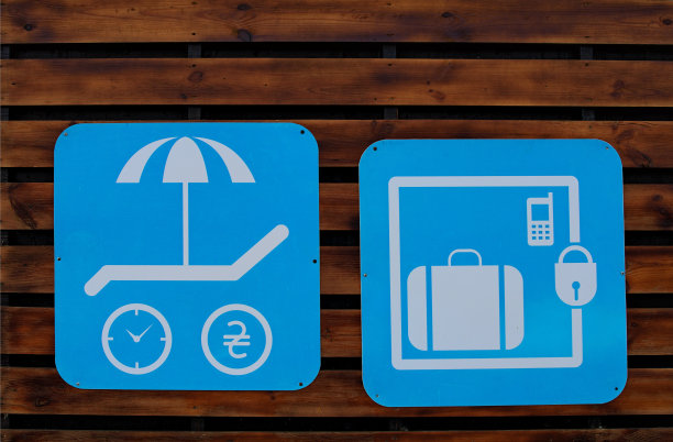 蓝色背景的行李寄存标志。蓝色背景上的沙滩伞和太阳躺椅标志。木墙上的标志。乌克兰基辅Hydropark的威尼斯海滩图片下载