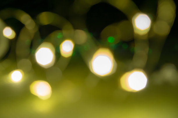 散景照片，模糊的黄色灯光和小的绿色灯光在黑暗的背景图片下载