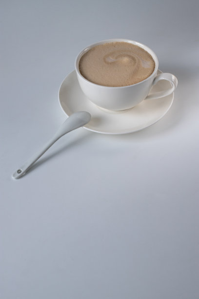 用白色的杯子和茶托盛着牛奶的美式咖啡。早晨喝咖啡图片下载