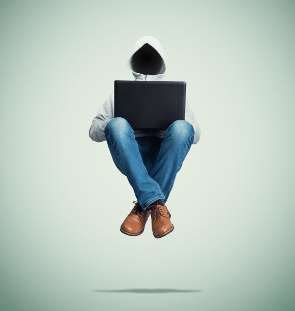 身穿连帽运动衫、没有脸的匿名黑客悬浮在空中，膝盖上放着一台笔记本电脑，背景是绿色的。图片下载