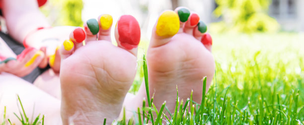 孩子们的脚上画着一幅微笑的绿色草地。有选择性的重点。图片下载