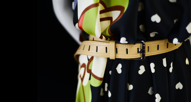 浅色丝绸连衣裙上的米色腰带。拷贝空间的黑色背景。图片下载