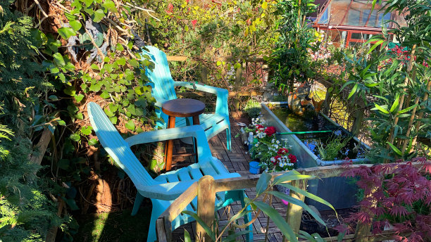 花园树屋露台露台阳台在春天与柚木装饰瓷砖壁画用餐区，锌槽池与太阳能喷泉泵，俯瞰整个家庭花园图片下载