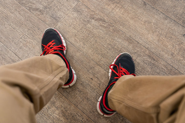 男人的脚在硬木地板上图片下载