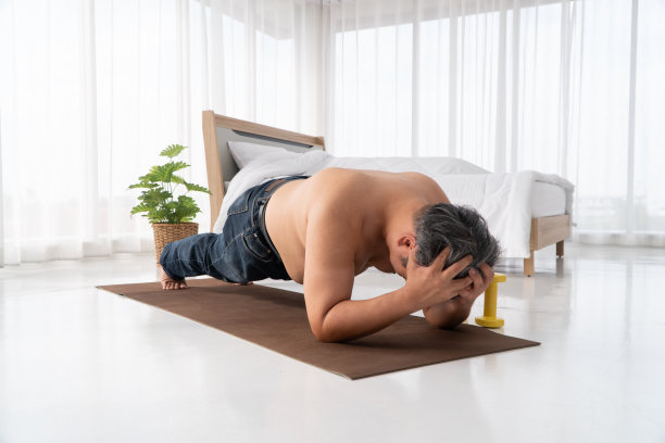 肥胖的亚洲男人正在努力做平板支撑，努力减肥。出门上班前要进屋。为了健康而锻炼的概念。图片下载