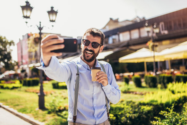 英俊的年轻人用手机自拍图片下载