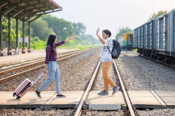 一对时尚的游客背着背包，在户外地铁站进入火车，亚洲夫妇旅游火车站复古风格的概念，在泰国图片下载