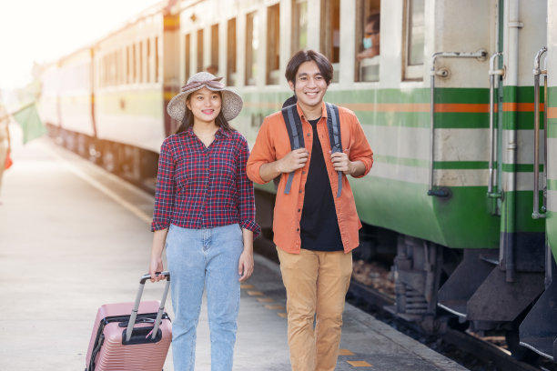 一对时尚的游客背着背包，在户外地铁站进入火车，亚洲夫妇旅游火车站复古风格的概念，在泰国图片下载