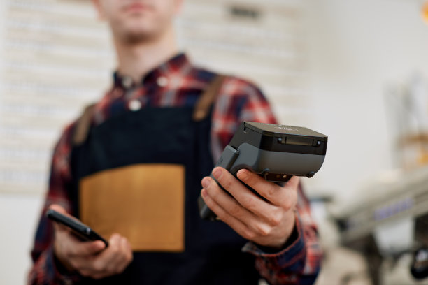 停机坪上的咖啡师手持现代银行支付终端图片下载