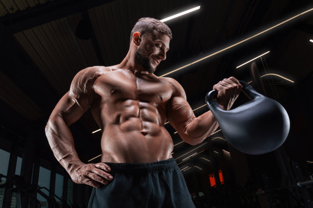 在健身房摆姿势，手持壶铃的健壮男人。健身概念。图片下载