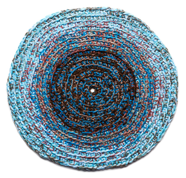 用粗线钩编的蓝色圆垫子。孤立在白色背景上图片下载