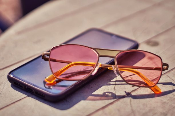 太阳镜和一部手机图片下载