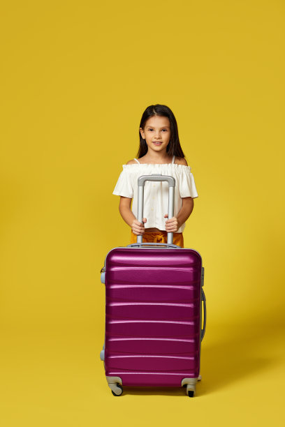 快乐的小女孩戴着帽子和粉红色的手提箱图片下载