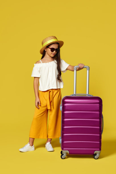 快乐的小女孩戴着帽子和粉红色的手提箱图片下载