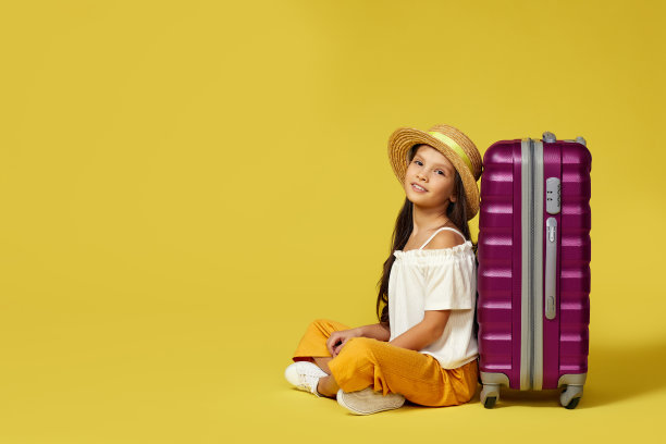 小女孩拿着旅行箱和护照坐在地板上图片下载